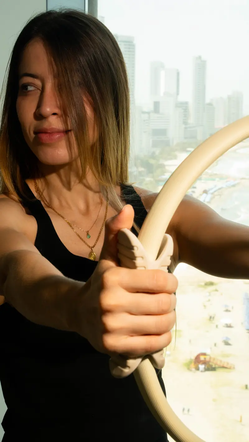 Clienta con anillo de Pilates frente al ventanal con vista a las playas de Bocagrande